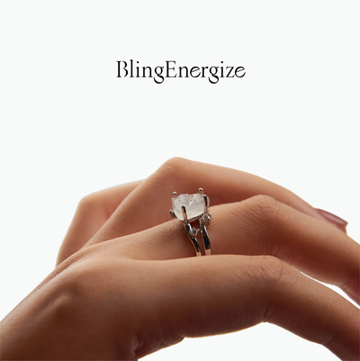 Hand wearing a diamond ring with 'BlingEnergize' branding on a white background